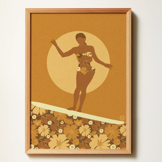 Framed artwork of a silhouette of a woman on a surfboard with floral patterns and a sun in the background.