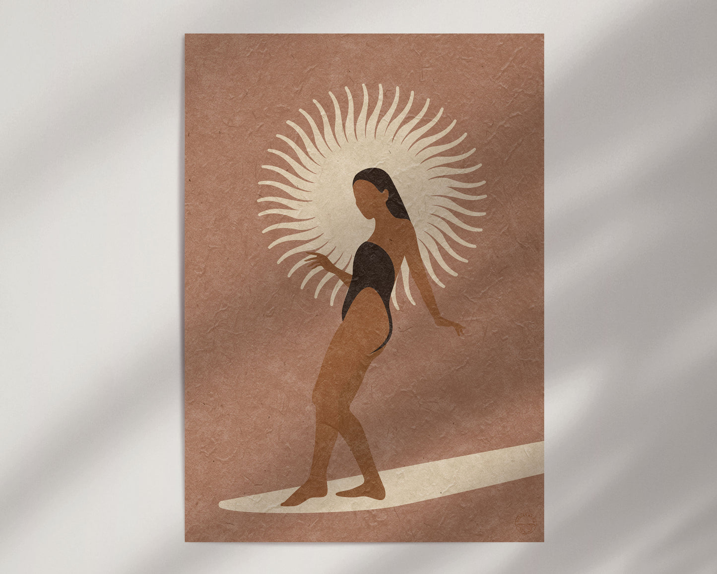 An art print of a female figure in a swimsuit standing on a board with a sun motif in an terracotta colored background.