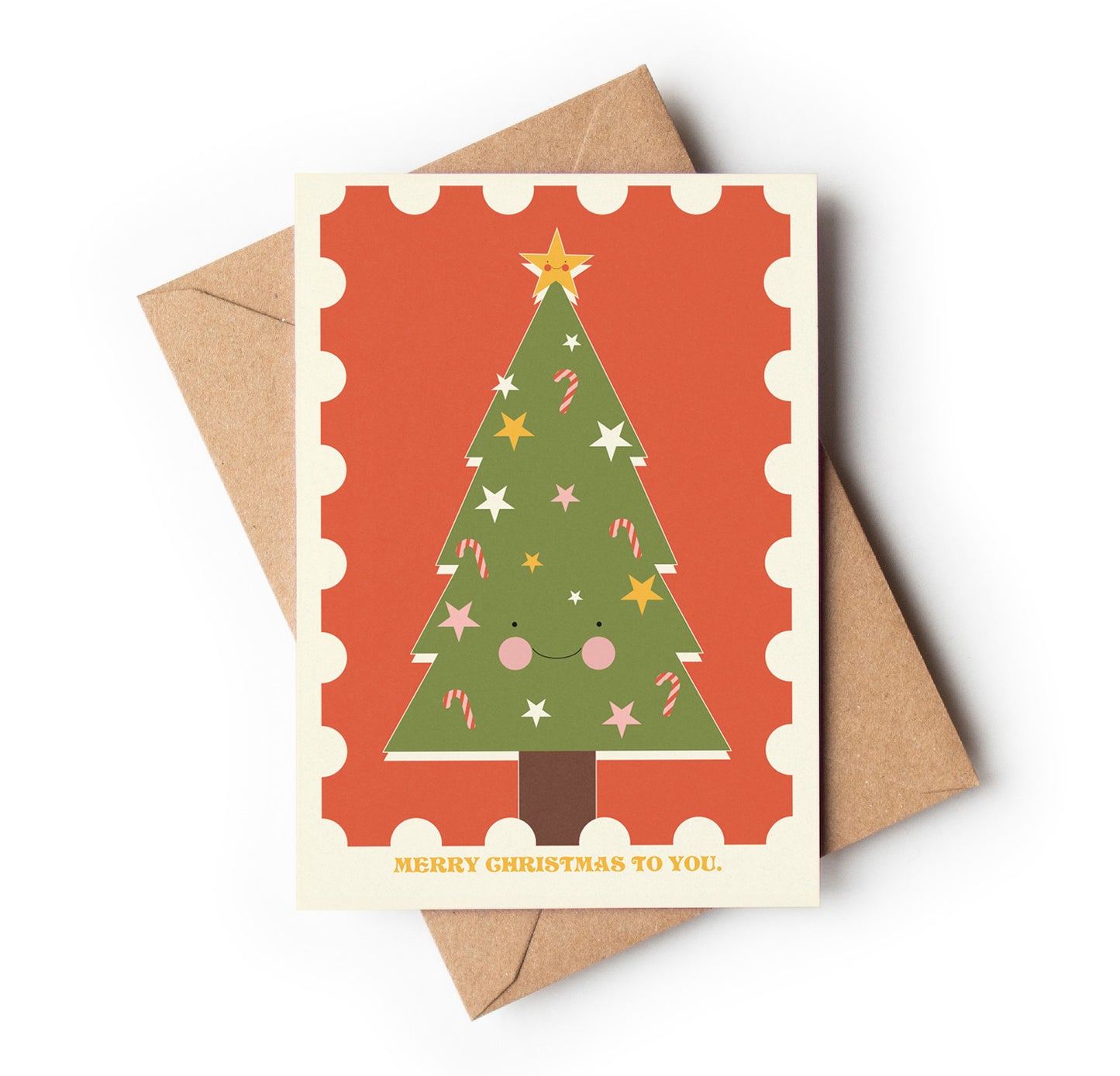 Christmas card with a smiling Christmas tree design on an orange background, featuring a brown envelope.