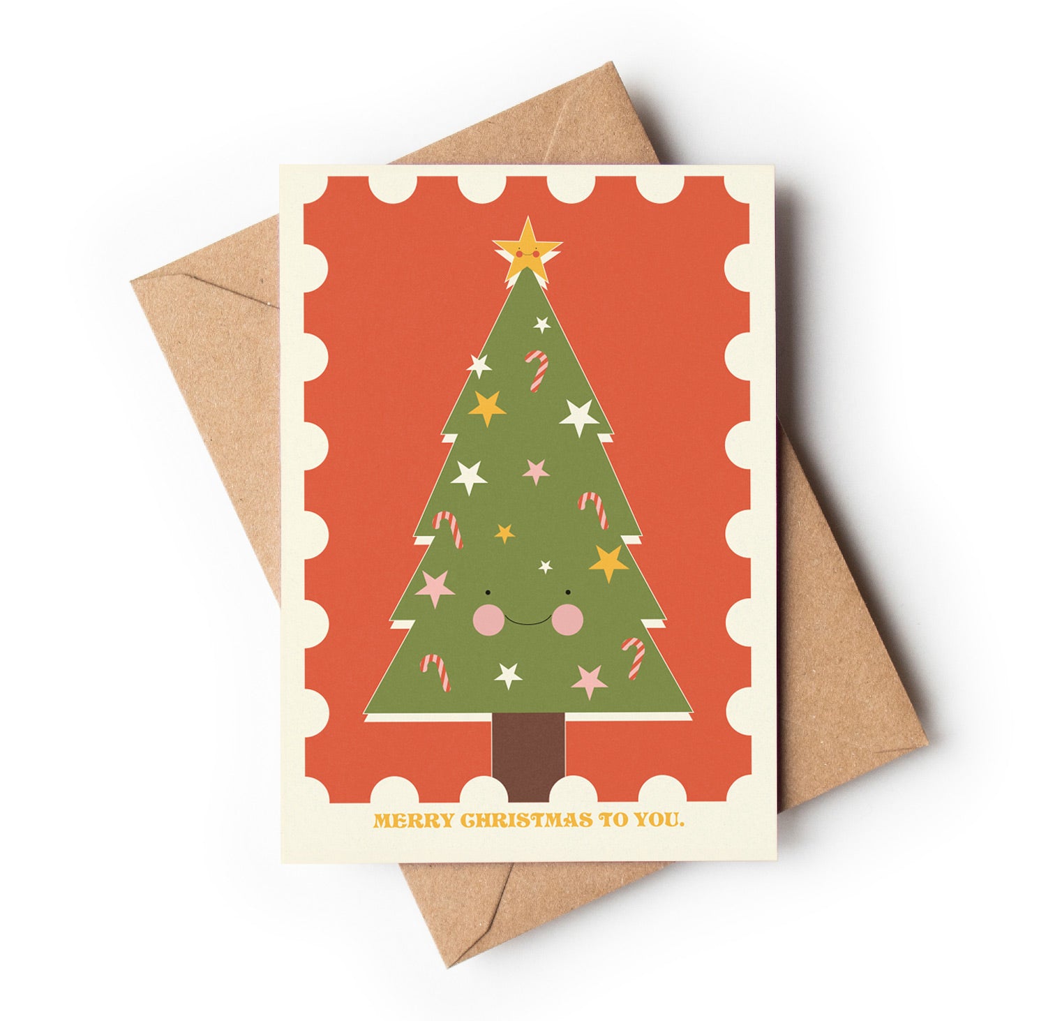 Christmas card with a smiling Christmas tree design on an orange background, featuring a brown envelope.