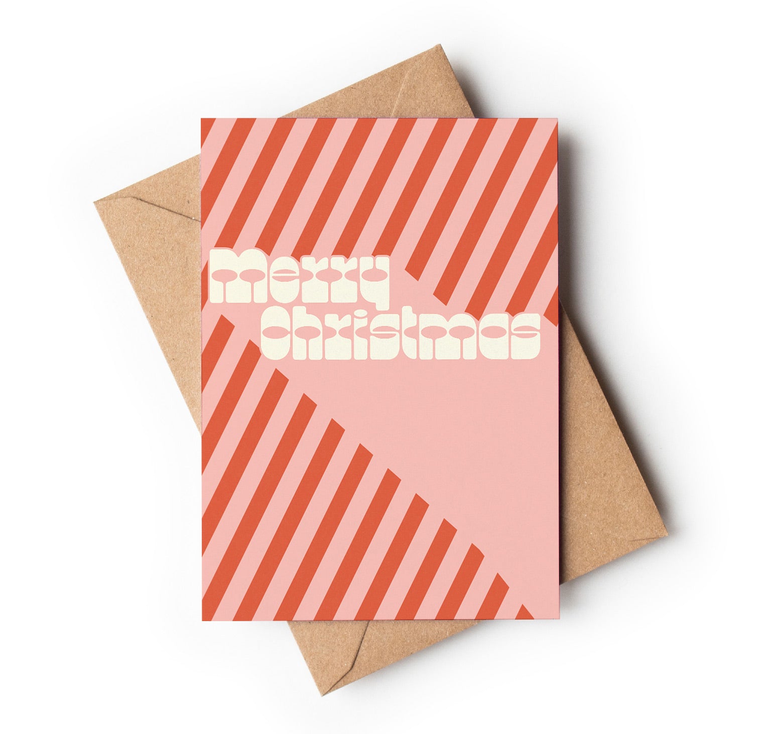 Pink Christmas card with red stripes and 'Merry Christmas' text, placed on a brown envelope.