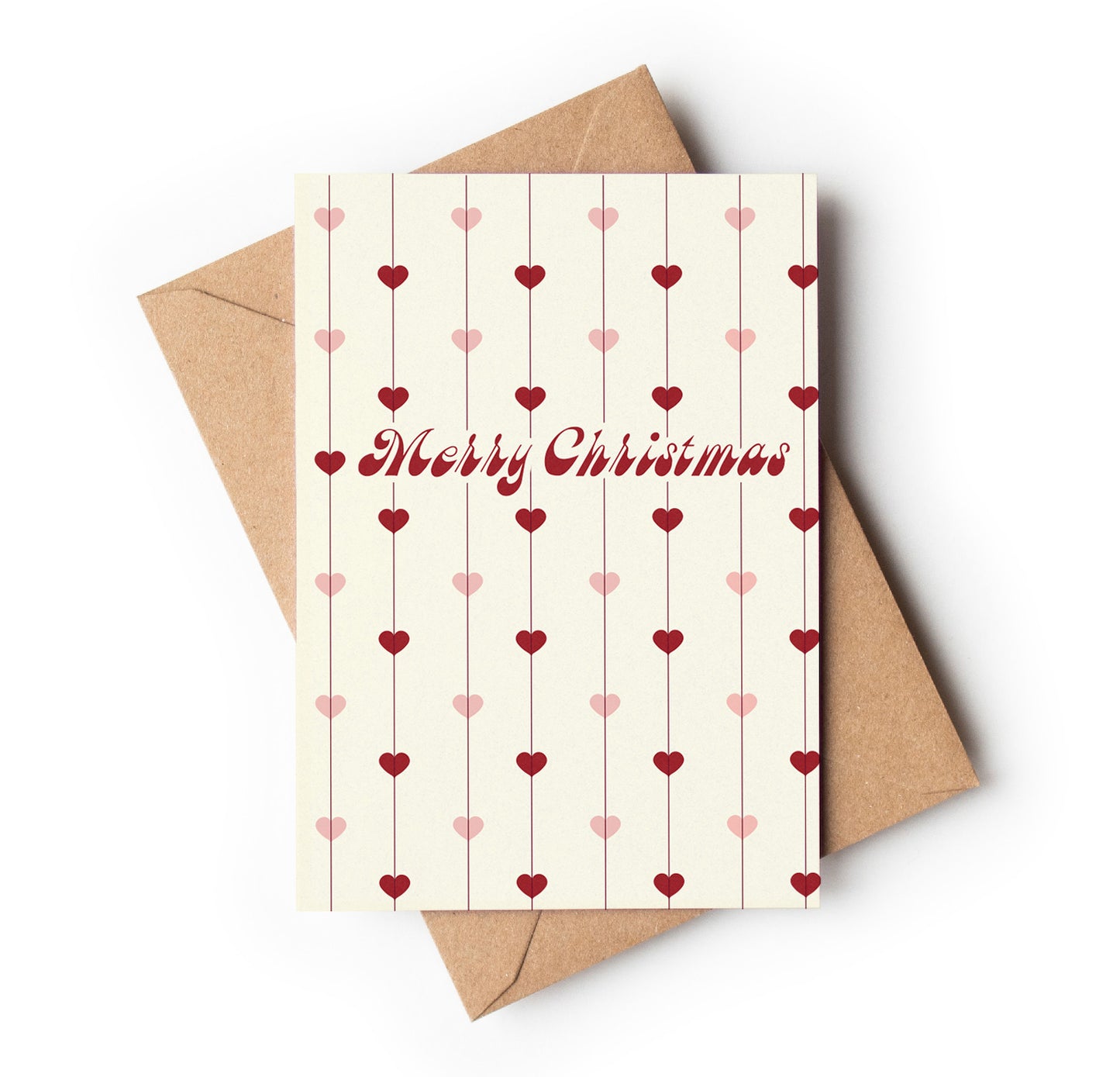 Christmas card with heart patterns and 'Merry Christmas' text, accompanied by a brown envelope on a white background.