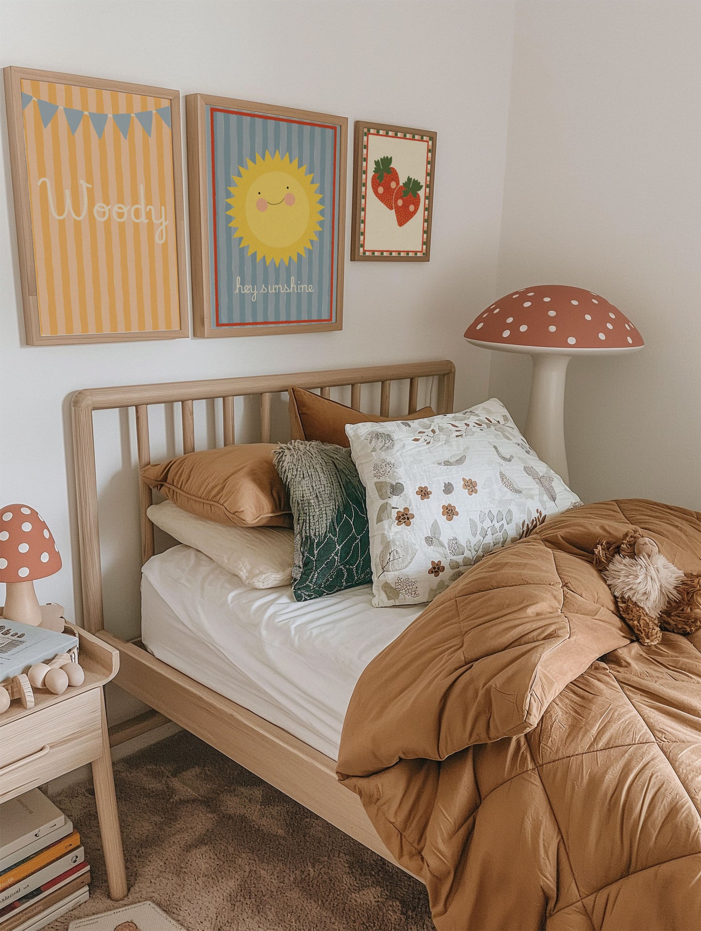 Children's bedroom with wooden bed, colorful pillows, and wall art.