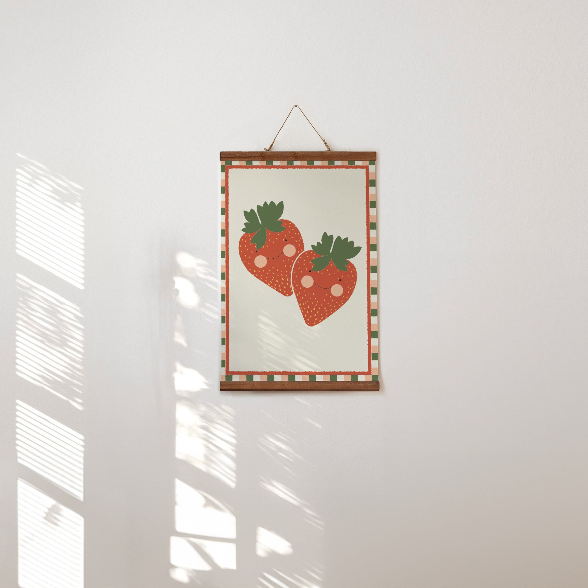 Framed artwork with strawberry design on a white wall